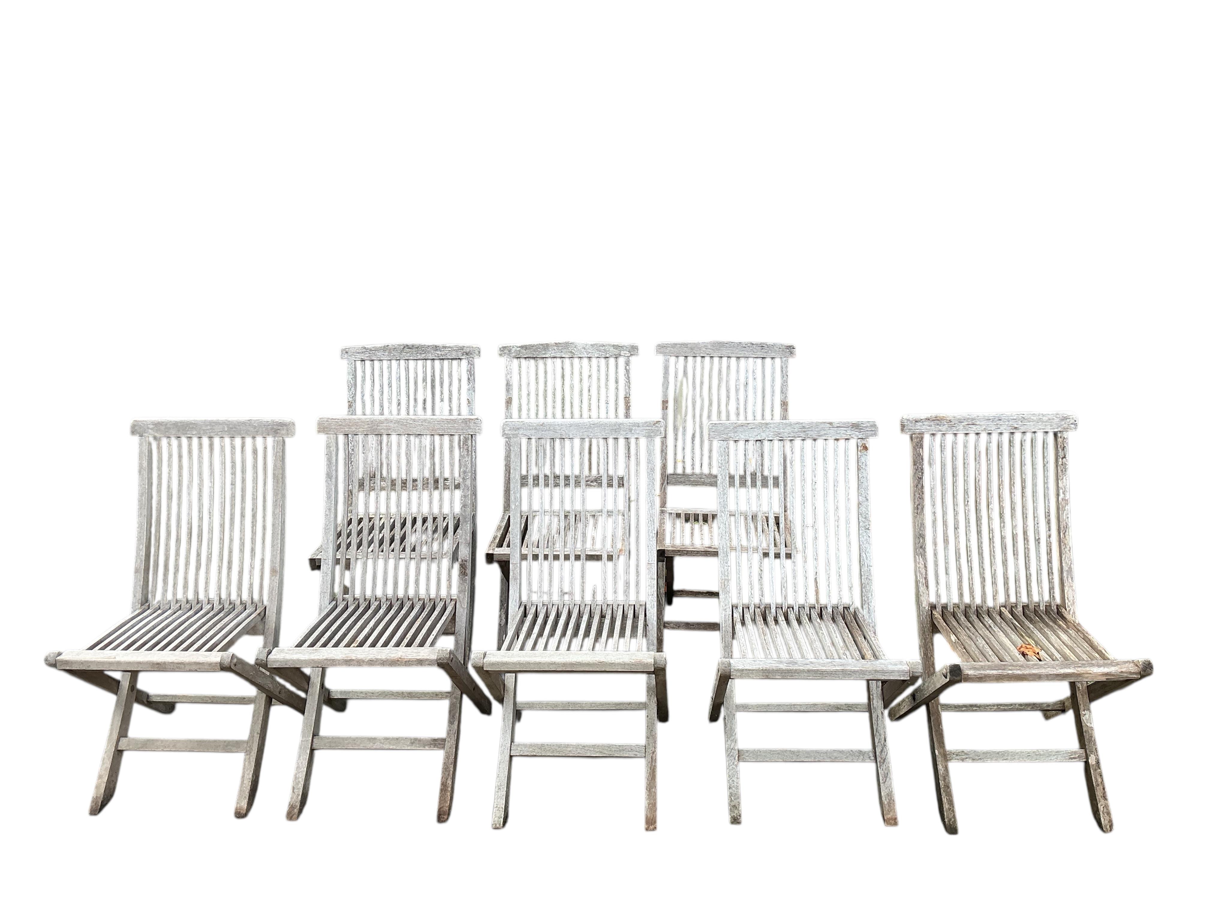 A Laidlays teak oval extending garden table, width 169cm extended, depth 120cm, height 75cm together with eight folding weathered teak garden chairs